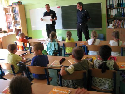 Uczniowie podczas spotkania z policjantem i strażnikiem miejskim