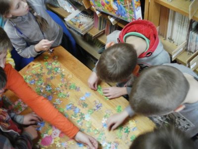 Dzieci układają puzzle z motywem Kubusia Puchatka