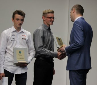 Statuetkę z rąk przewodniczącego Janusza Podżorskiego odbiera Tomasz Raszyk