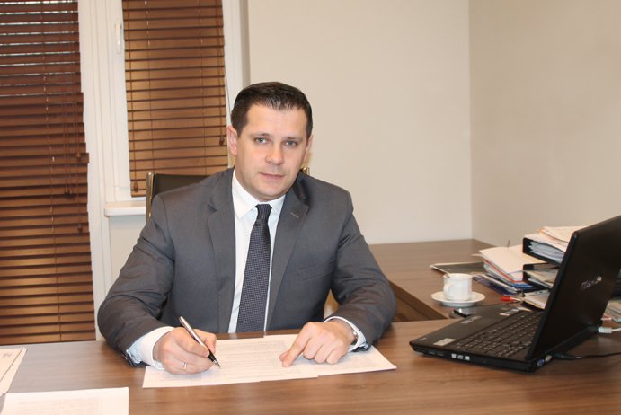 Tomasz Bujok - Burmistrz Miasta Wisła siedzący za biurkiem